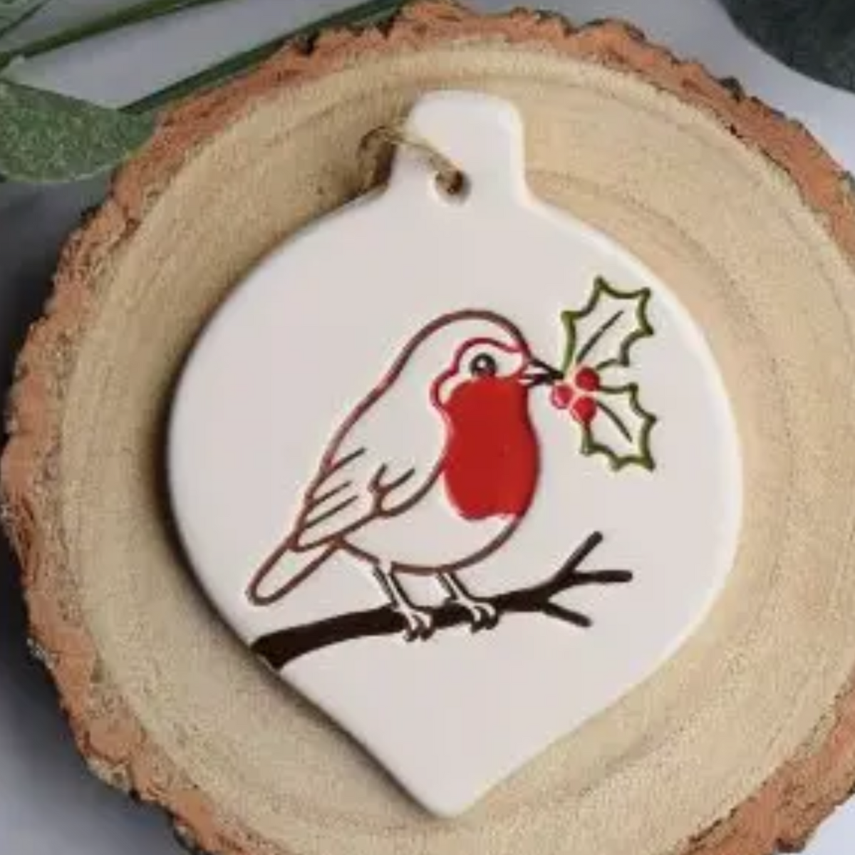 Ceramic bauble shaped Christmas decoration of robin with holly