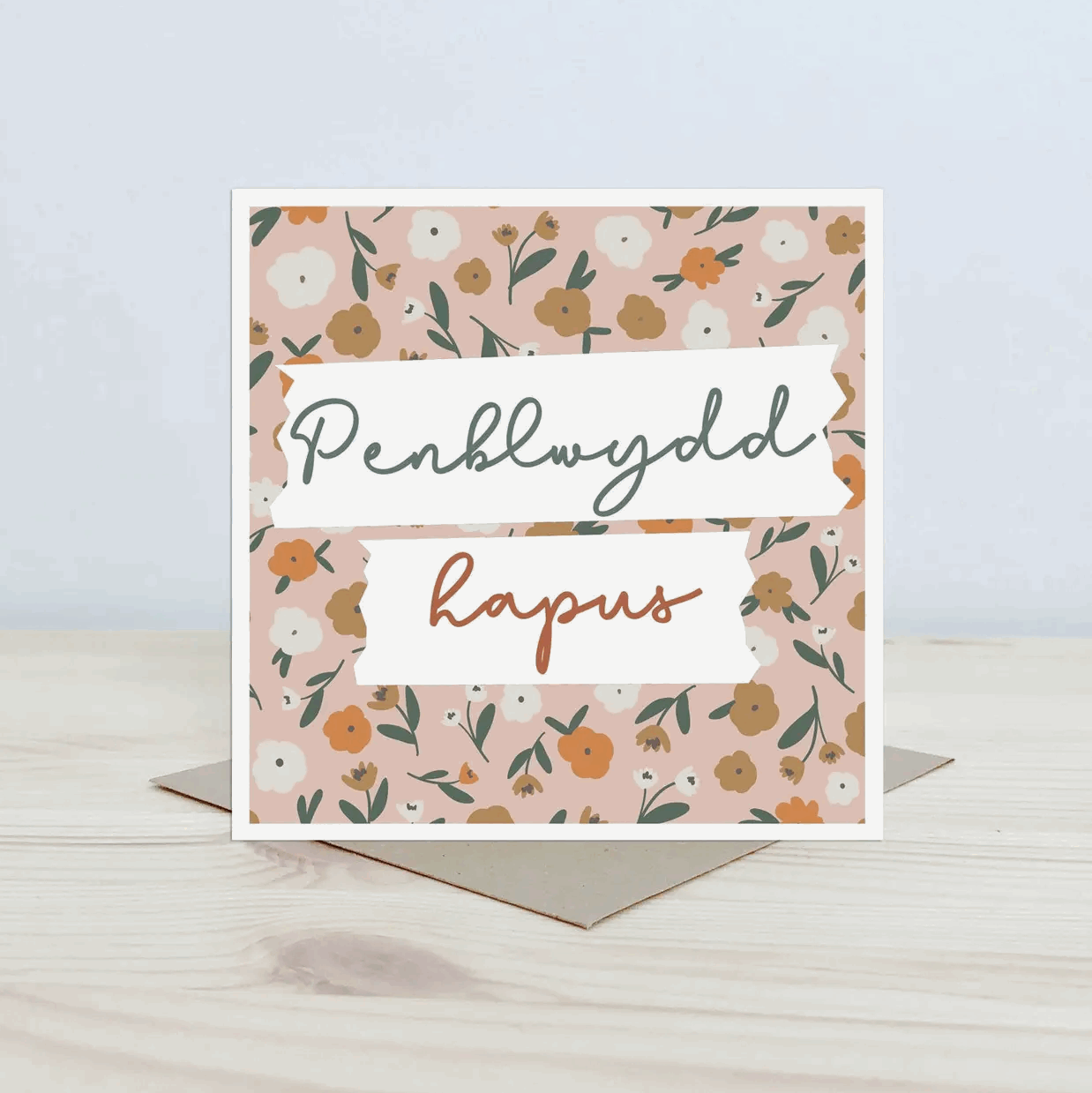 Greeting card with floral design and penblwydd hapus text on a light surface